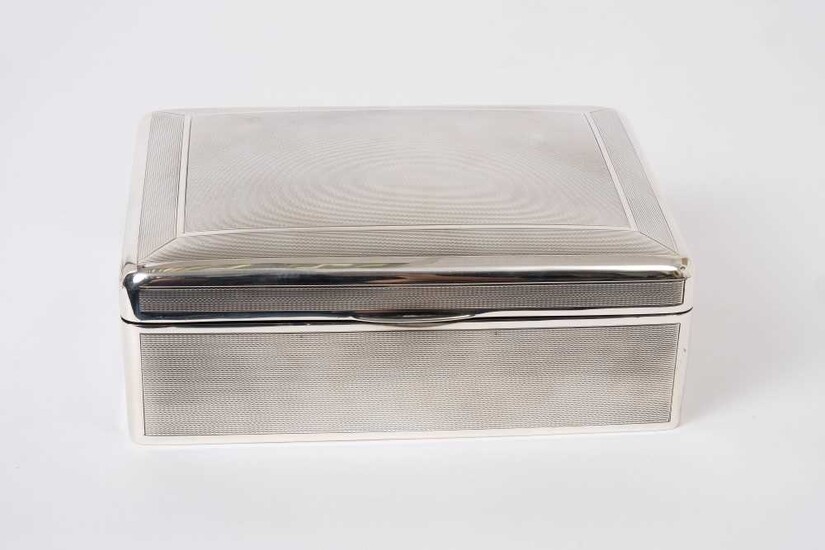 Large George V silver cigarette box of rectangular form with engine turned decoration, domed hinged cover with gilded interior opening to reveal cedar lined interior, (Birmingham 1912)