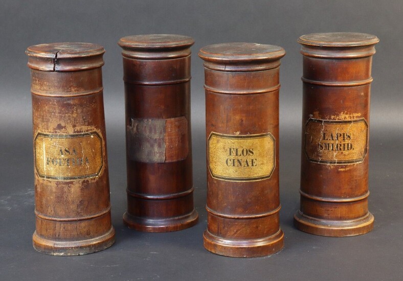 Set of four turned wood apothecary jars with interlocking lids. Paper labels. 19th century. Height 20 cm. Cracks