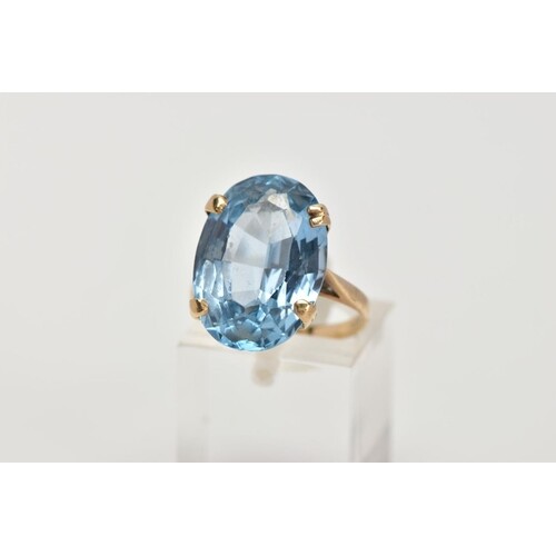 A 9CT GOLD BLUE TOPAZ DRESS RING, designed with a four claw ...