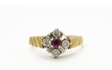 A 9ct gold ring set with central ruby bordered by four diamo...
