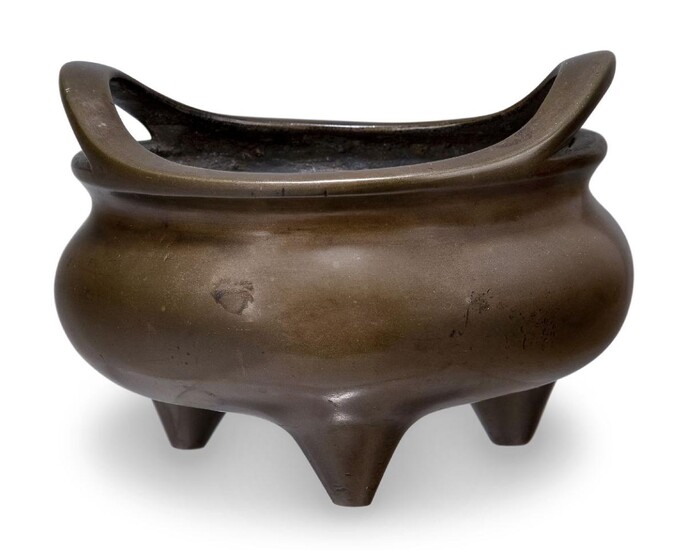 A Chinese bronze bombe tripod censer, 18th/19th century, with two raised handles, apocryphal Xuande mark to base, 13cm diameter