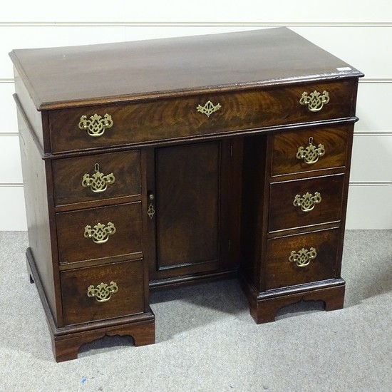A George III mahogany knee-hole desk with alcove cupboard, w...