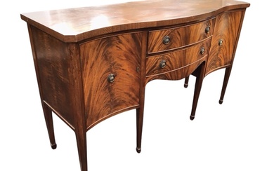A Georgian style mahogany sideboard, the serpentine fronted top above...