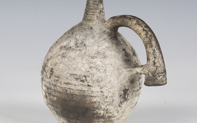 A Middle Eastern Bronze Age black ware flask, probably Iran, the ribbed spherical body incised with