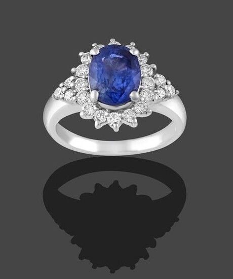A Sapphire and Diamond Cluster Ring, the oval cut sapphire...
