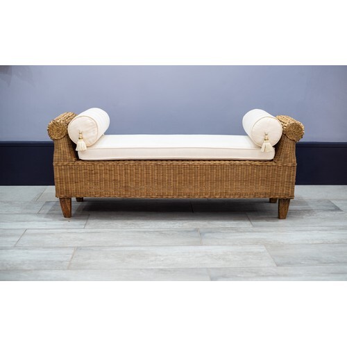 A WICKER WINDOW SEAT The loose seat cushion with two bolster...