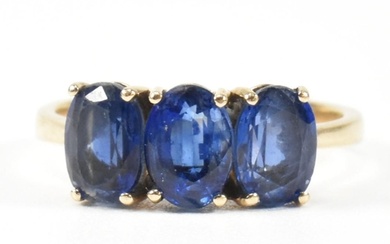 A hallmarked 9ct gold and synthetic sapphire three stone rin...