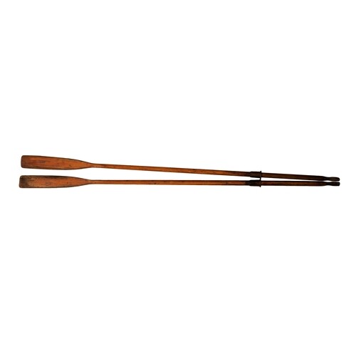 A large pair of vintage wooden rowing boat oars, with brown ...