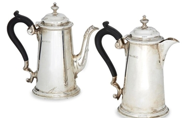 A pair of Edwardian silver café-au-lait pots, London, c.1907 and 1908, Marples & Co., of tapering cylindrical form with stepped round bases, scroll handles and hinged lids, 16.5cm high, total weight approx. 18.2oz (2)