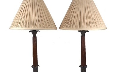 A pair of bronze and wood table lamps, late 20th century, the reeded tapering shafts on triform bases with paw feet, 53cm excluding fitment (2) It is the buyer's responsibility to ensure that electrical items are professionally rewired for use.