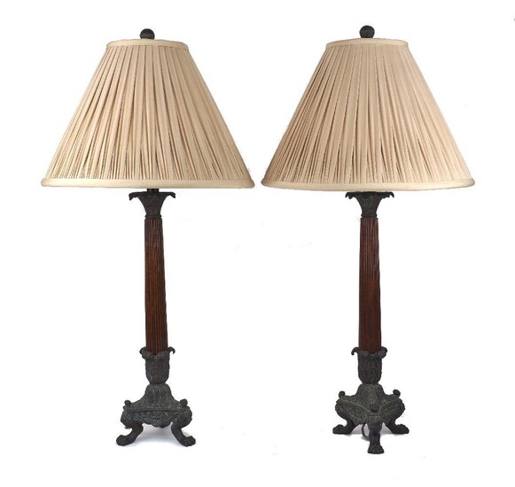 A pair of bronze and wood table lamps, late 20th century, the reeded tapering shafts on triform bases with paw feet, 53cm excluding fitment (2) It is the buyer's responsibility to ensure that electrical items are professionally rewired for use.