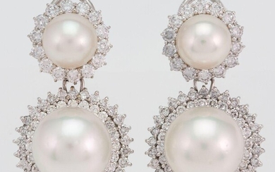 A pair of diamond and cultured pearl earrings, each supporting a cultured pearl drop surrounded by brilliant-cut diamonds to a similar surmount, clip and post fittings
