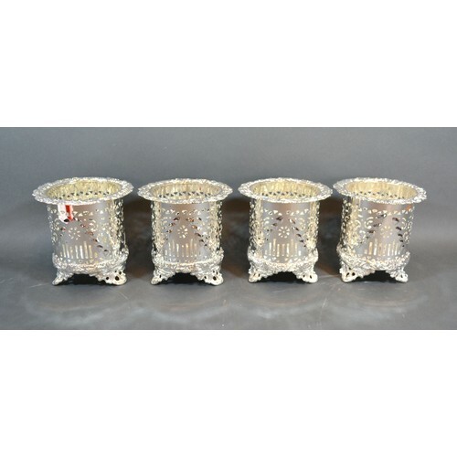 A set of four silver plated bottle coasters of pierced form,...