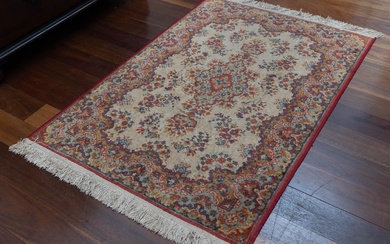 A small vintage woollen floral Persian rug in pastel colours on an ivory ground.100 x 145cm