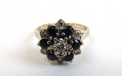 An 18ct white gold, diamond and sapphire cluster ring. Approx....