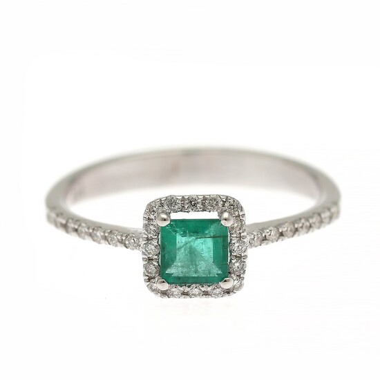 An emerald and diamond ring set with a carré-cut emerald encircled by numerous brilliant-cut diamonds, mounted in 14k white gold. Size 54.5.