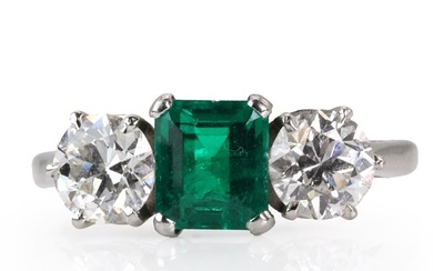 An emerald and diamond three stone ring