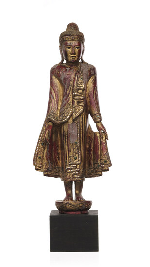 Bouddha debout en bois laqué et doré, Birmanie, moderne, debout sur un piédestal lotiforme, la main gauche tenant le pan de sa robe, incr