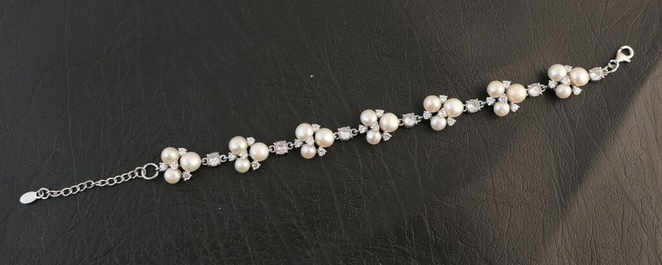 Bracelet en argent orné de 21 perles de culture et pierres blanches.Poids brut:17,6g