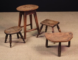 Four 19th Century Country Stools: One with a replaced oval top pierced with three finger holes, standing on a joined ash base of square legs united by peripheral stretchers 19 in (48 cm) high, 15 in x 11 in (38 cm x 28 cm). A rectangular topped stool