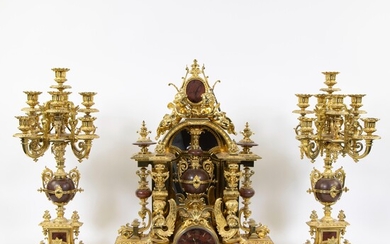 Imposing fire-gilt bronze/brass clock with marble, decorated with cherubs, medallions and sphinx women, with 2 candlesticks with 8 light points. Medal d'Argent.