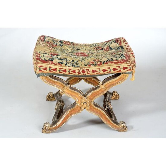 PLOYING TABOURET in gilded wood and carved with large flowers and scroll patterns. Its base is finely drawn X-shaped. The seat is in fine tapestry (in old condition). Ep.early 18th century. L.56 P.45 H.47.