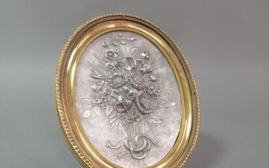 Plaque en argent en semi relief à décor d'un bouquet de fleurs.
