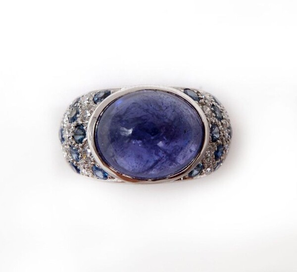 RING in 18K white gold holding a 5.60 carat tanzanite cabochon in a surround of sapphires and pavé diamonds. French work. TDD: 51. Gross weight : 10.90 gr. A 5.60 carats tanzanite, sapphire, diamond and gold ring.