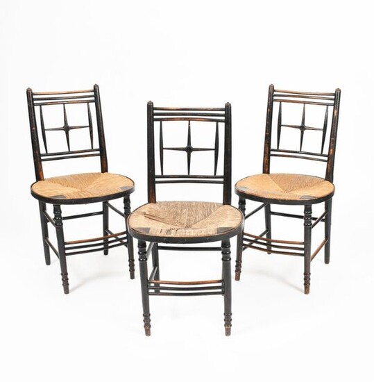 Three Morris & Co Sussex ebonised wood chairs, possibly designed by Ford Maddox Brown, each with slightly curved backs, set with turned, cross back splat design, circular rush seat, on turned leg and stretchers, unsigned, 84.5cm. high, (3) Provenance...