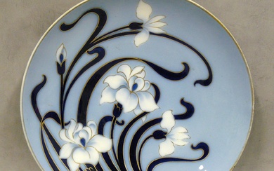un plat en porcelaine de limoges à décor floral, Art Nouveau sur fond bleu, signé...