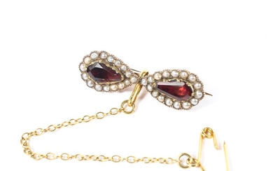A 19th century 9ct gold garnet and seed pearl bow brooch set with two pear cut foil backed garnets