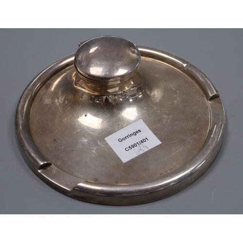 A George V silver circular inkwell, the rim with pen recess,...