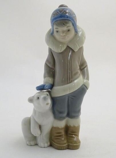 A Lladro figure of a boy with a polar bear cub, model