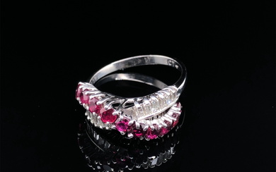 A MID 20th CENTURY RUBY AND DIAMOND RING. THE RING DESIGNED AS CROSS OVER RING, WITH A RAISED RUBY