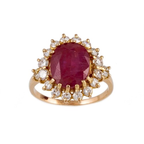 A RUBY AND DIAMOND OVAL CLUSTER RING, the oval cut ruby to a...