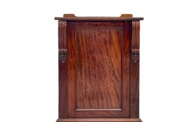 A Victorian mahogany pedestal cupboard. The door with volute...