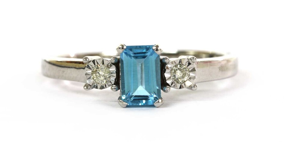 A white gold blue topaz and diamond three stone ring