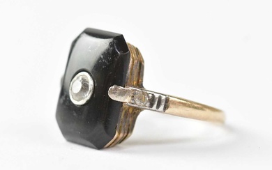 A yellow metal ring, set with an onyx and white...