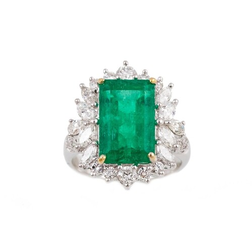 AN EMERALD AND DIAMOND CLUSTER RING, the rectangular cut eme...