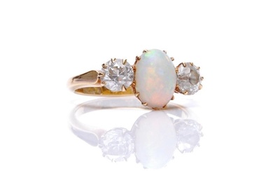 An 18ct opal and diamond three stone ring, central oval opal...