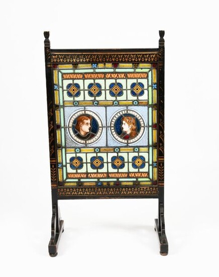 An Aesthetic Movement stained glass and ebonised wood fire screen in the style of Dr Christopher Dresser, the frame with stencilled geometric flower motif in gilt, the glass with roundel portrait panels, amongst geometric borders, unsigned, 118cm...