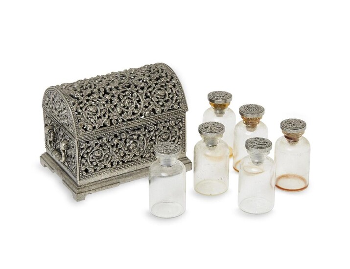 An Indian white metal medicine casket, Rajasthan, 19th century, decorated overall with pierced scrolling foliate motifs, the domed cover opening to six glass bottles, 9.3cm wide