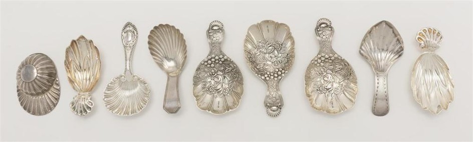 NINE STERLING SILVER TEA CADDY SPOONS 1-3) Three with repoussé floral design. Marked "MMA". 4-5) Two shell-form. Marked "MMA". 6) On...