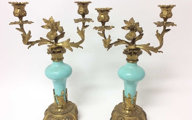 Pair of rococo ormolu and porcelain twin branch candelabra, with bulbous duck egg inverted baluster porcelain stem and removable twin scrolling foliate branches with removable sconces, on scrolling...