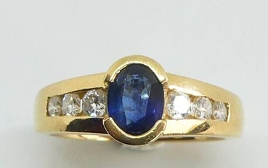 RING in yellow gold set in a half-closed setting with a facetted oval sapphire, the setting enhanced on either side by a line of diamonds. Gross weight 6.79 g TDD 51