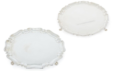 Two shaped circular salvers with piecrust borders, the larger example Sheffield, 1929, Atkin Bros, raised on four scrolling ball feet, 37.5cm dia., the smaller London, 1919, C. S. Harris & Sons, raised on three pad feet, 31.5cm dia., total weight...