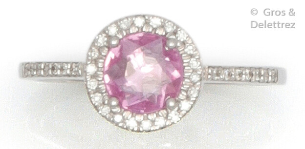 White gold ring set with a round pink sapphire surrounded and shouldered by brilliant-cut diamonds. Tour of doigt : 54. P. Brut : 2.2 g.