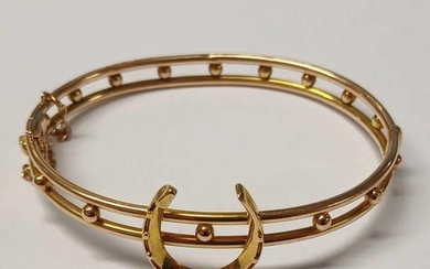 18CT GOLD HINGED BANGLE SURMOUNTED WITH HORSE SHOE, STAMPED ...