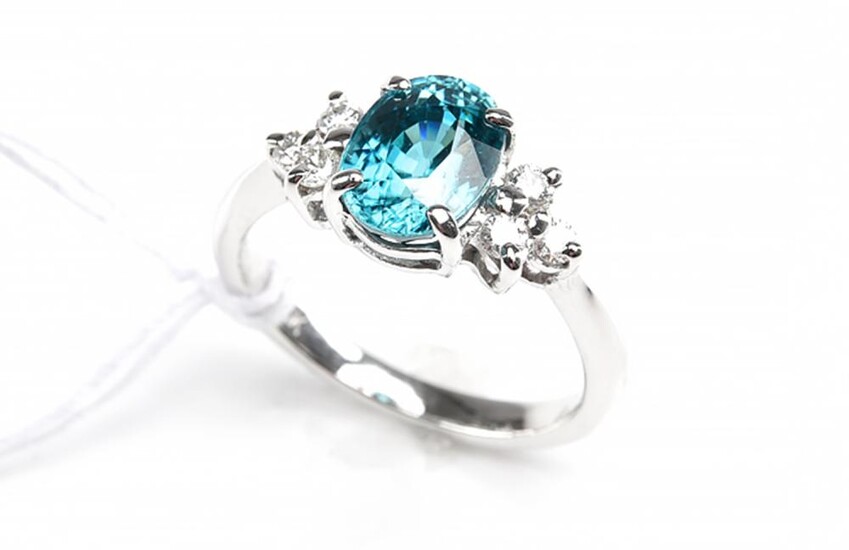 A BLUE ZIRCON AND DIAMOND DRESS RING, CENTRALLY SET WITH AN OVAL CUT BLUE ZIRCON WEIGHING 3.18CTS, IN 18CT WHITE GOLD, SIZE M, 4GMS