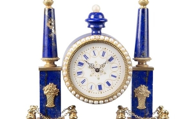 A Continental gilt-brass mounted lapis lazuli miniature timepiece, early 20th century, the white enamel dial with Roman numerals and pearl bezel, flanked by obelisks, on a rectangular base, original green velvet and silk-lined leather case, lacking...